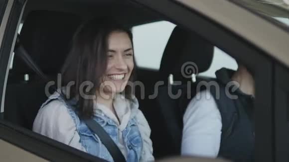 女人坐在新买的车里环顾四周在窗外挥舞着手视频的预览图