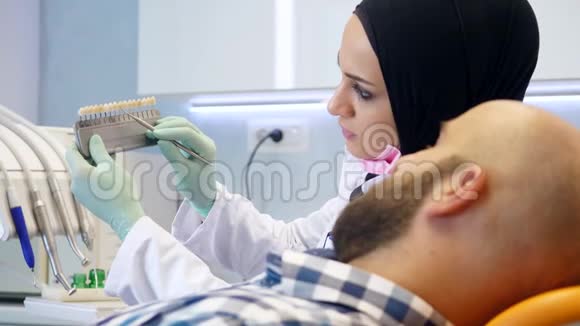 戴头巾的女牙医建议她的病人服用哪种牙齿颜色视频的预览图