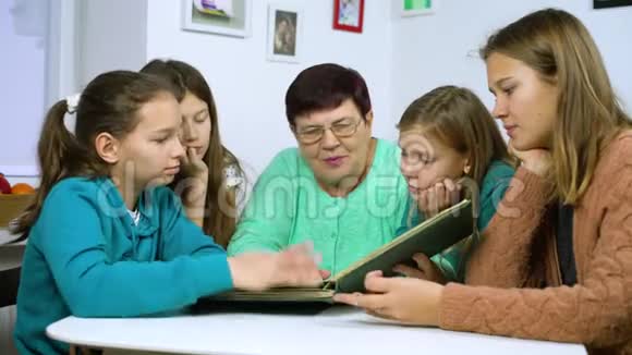 女孩们和祖母一起看旧相册视频的预览图