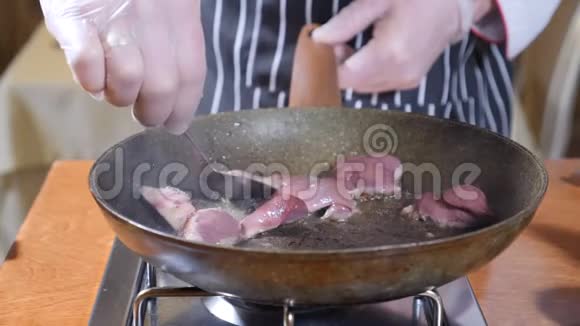 在餐厅的一个热煎锅上加入肝片的厨师烹饪弗拉姆贝式菜肴用勺子搅拌视频的预览图