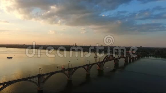 在第聂伯河上的铁路桥的鸟瞰图德尼普罗德内普罗彼得罗夫斯克市在美丽的日落中拍摄视频的预览图