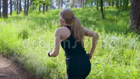 夏季绿林中女子独自慢跑的后景视频的预览图