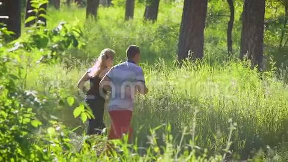 两个穿着运动服的人在绿色木材的背景下奔跑视频的预览图