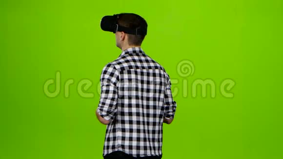 头戴虚拟现实眼镜的男人后视图绿色屏幕视频的预览图