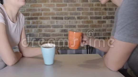 在餐桌上喝茶的年轻男女视频的预览图