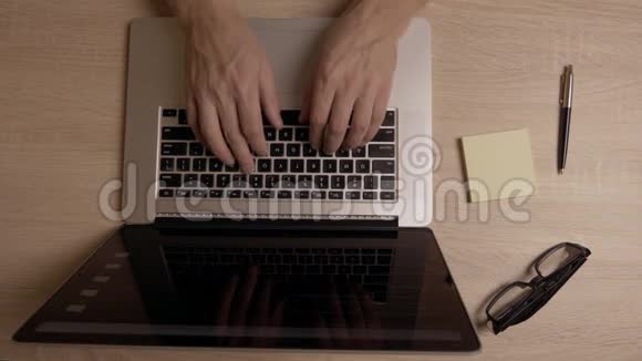 人手上网在笔记本电脑的顶部视图浏览互联网新闻桌上的玻璃笔和备忘贴纸视频的预览图