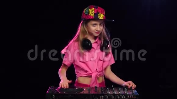 戴着亮帽子的女孩在DJ键盘上弹奏慢动作视频的预览图