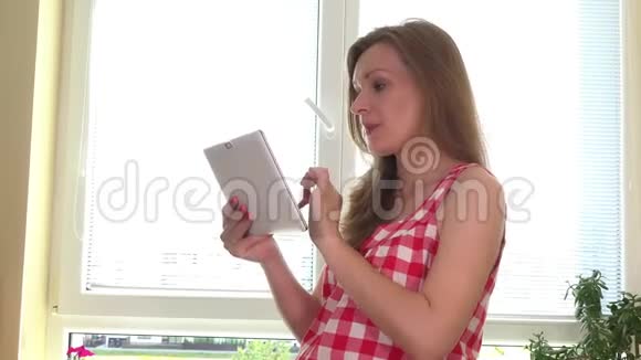 有平板电脑的孕妇在家准备蔬菜沙拉视频的预览图
