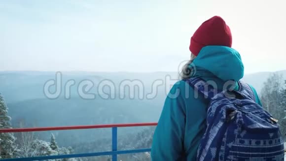 年轻的女游客在冬天在智能手机上拍照拍摄雪山的照片视频的预览图