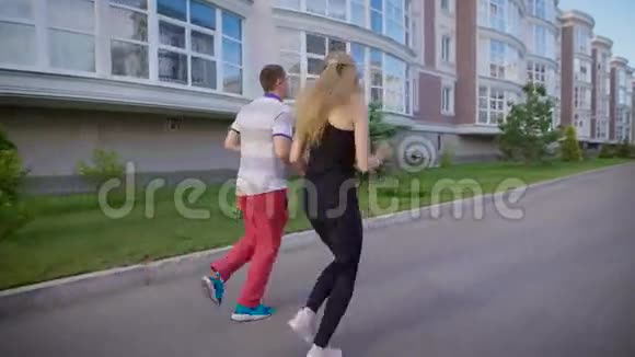 夏天两个人一起在街上的建筑物旁奔跑视频的预览图