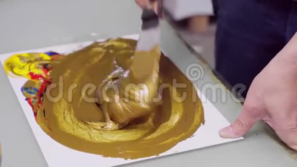 人把颜料混合到金黄色在包装产品上印上标识视频的预览图