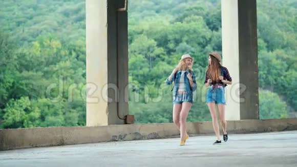 两个漂亮的女孩年轻的女性朋友旅行者走在户外的山景视频的预览图