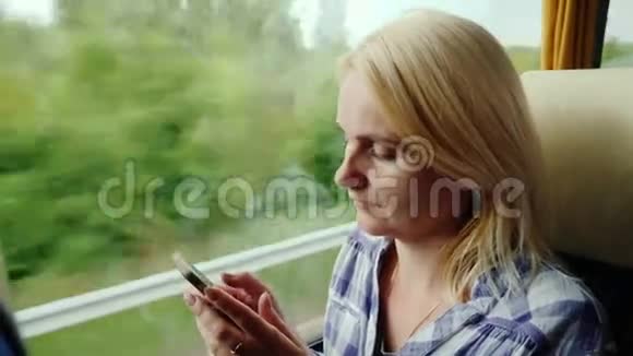 一个女人正在城外乘公共汽车使用手机视频的预览图