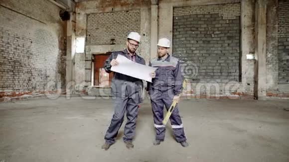 有计划的人在施工两名穿制服的建筑工人站在现场背景上探索视频的预览图