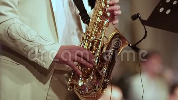一个穿白色西装的音乐家在萨克斯管上独奏视频从第一锐度到最后模糊视频的预览图