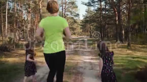 母亲和女儿正在夏天的森林里奔跑视频的预览图