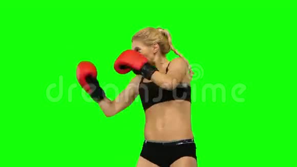 穿红色手套的女拳击手交替发手绿色屏幕侧视图视频的预览图