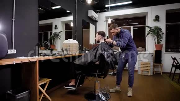 理发师在理发店的椅子上给顾客安装切割机视频的预览图