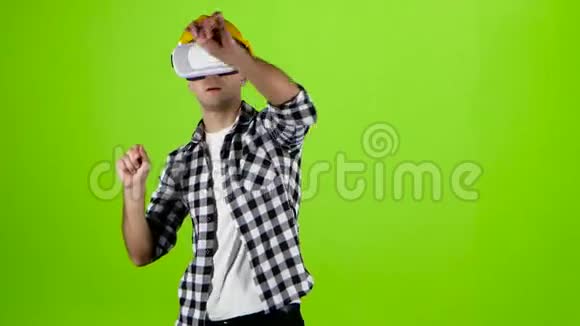黄色头盔工程师工作的VR眼镜绿色屏幕视频的预览图