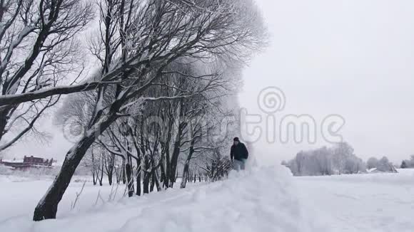 在公园的冬天人们穿过厚厚的雪视频的预览图