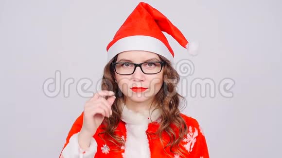 戴着圣诞老人帽子和眼镜的可爱女人视频的预览图