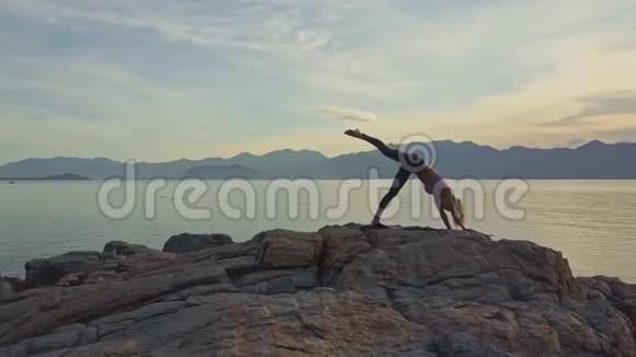 在日出的海面上Flycam绕着女孩做瑜伽视频的预览图