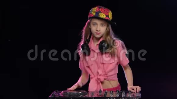 戴着亮帽子的少女在dj键盘上玩耍视频的预览图