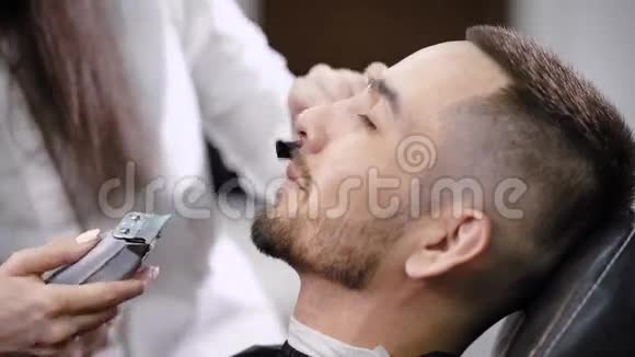 理发店里修饰工的人不可辨认的主梳理胡子视频的预览图