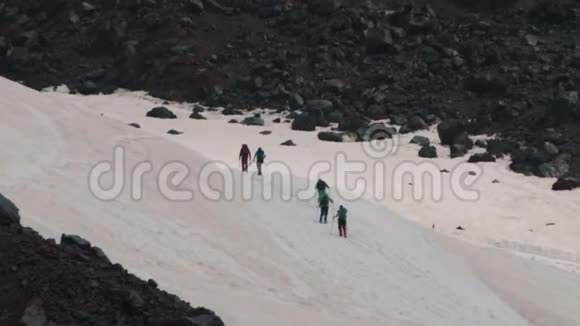 人们爬上游客在雪山山坡上散步视频的预览图