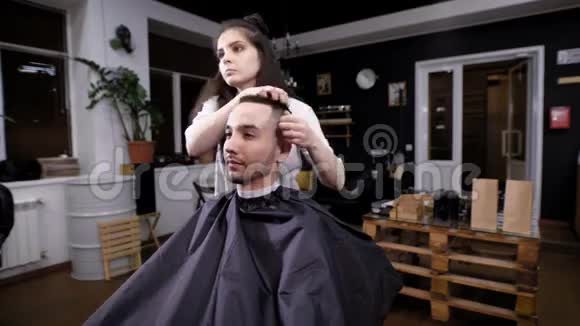 一位女理发师为理发店的访客完成发型设计一位发型师使用凝胶进行造型视频的预览图