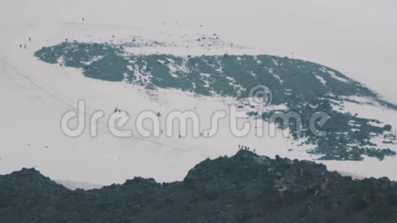 人们登山游客漫步在雪山坡上视频的预览图