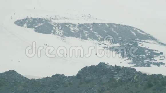 人们登山游客漫步在雪山坡上视频的预览图