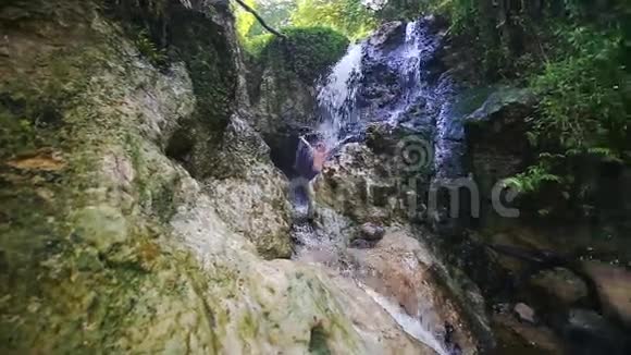 特写镜头在瀑布喷射下沐浴在岩石中视频的预览图