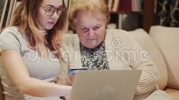 年轻女孩教她奶奶新的电脑技术视频的预览图