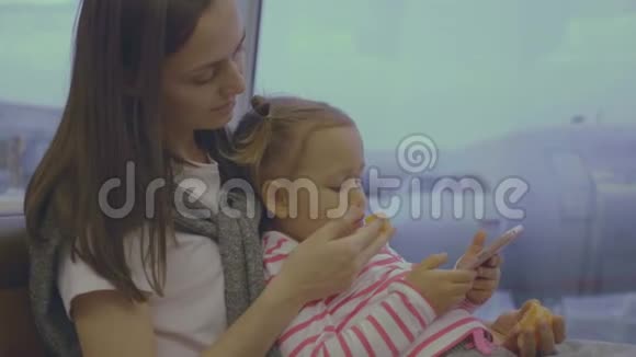 母亲在机场慢动作地用橘子喂小女儿视频的预览图