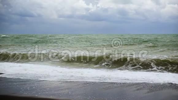 一股孤独的波浪在黑色的海岸上曲折缓慢视频的预览图