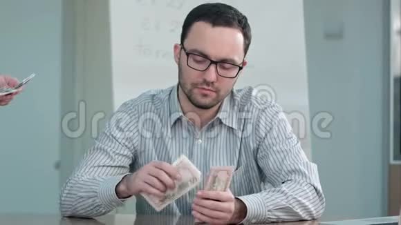 老师拿钱数美元钞票视频的预览图