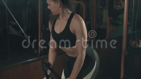 健身女子在黑暗健身房用举重训练机训练视频的预览图