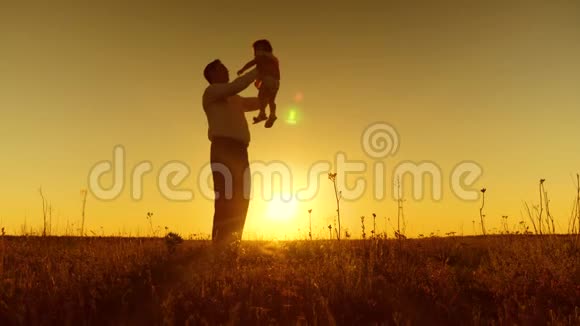 爸爸在日落时围着小孩子转快乐的爸爸和小女儿玩慢动作视频的预览图