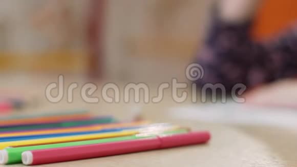 女孩用黄色毛毡尖笔在纸上画画视频的预览图