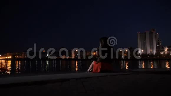 一个女孩坐在城市的栏杆上视频的预览图