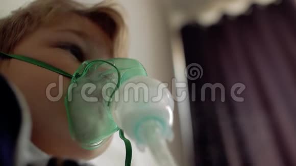 男孩坐在床上吸入病人脸上的吸入面罩视频的预览图