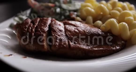 油炸多汁牛排意大利面食白盘上有蔬菜沙拉视频的预览图