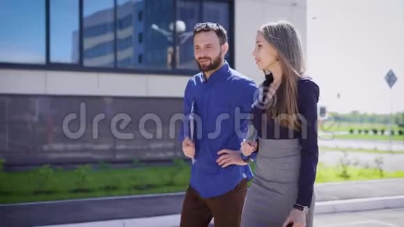 受欢迎的同事在午休时互相交谈一个忙碌的男人和女人在外面讨论工作时刻视频的预览图
