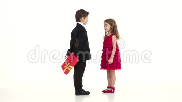 小男孩给了他女朋友一份礼物她轻轻地吻了他的脸颊白色背景慢动作视频的预览图