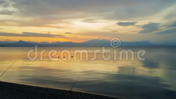 钓竿对夕阳在希腊的卢特拉基一个美丽而平静的夜晚视频的预览图