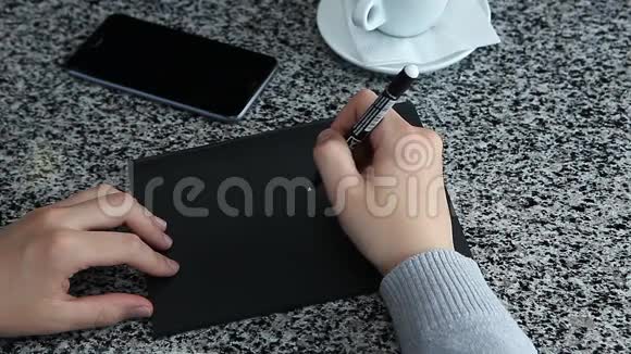 女人假装在黑纸桌上写字视频的预览图