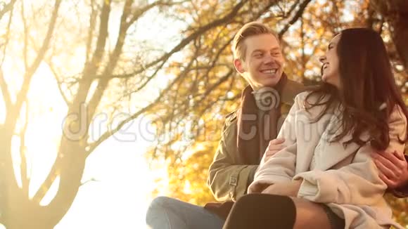 一对幸福的情侣坐在森林里的户外往一边看视频的预览图