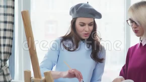 女艺术家在贝雷帽里拿着画笔微笑着视频的预览图