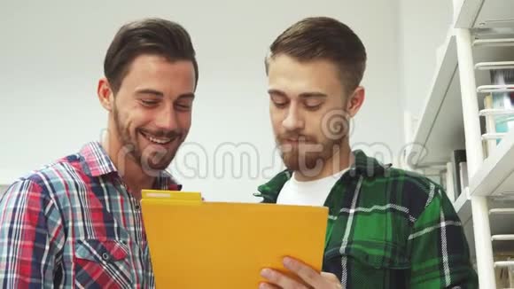 两个人在文件夹里看文件笑了视频的预览图